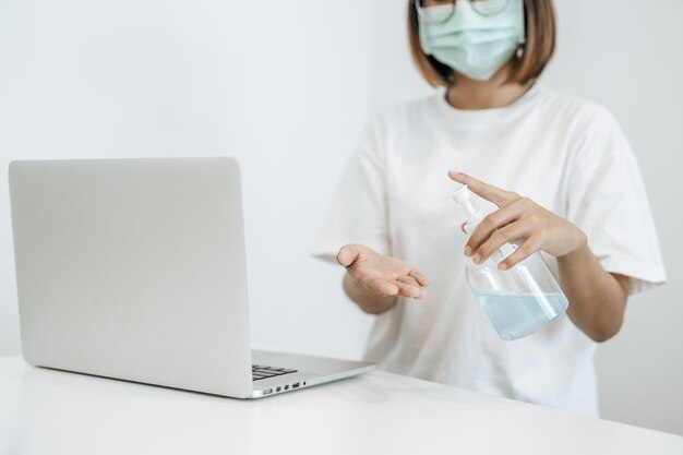 Mujeres con camisas blancas que presionan el gel para lavarse las manos y limpiarse las manos.