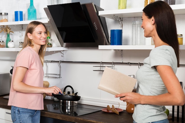 Mujeres en casa charlando con café y libro