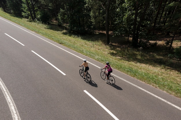 Foto gratuita mujeres ciclistas profesionales en carretera tiro completo