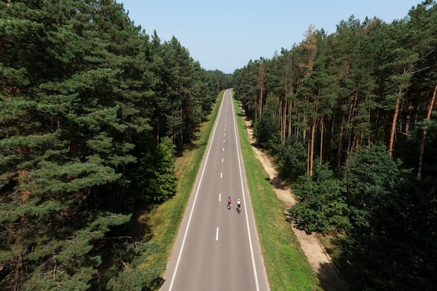 Mujeres ciclistas profesionales en la carretera tiro largo