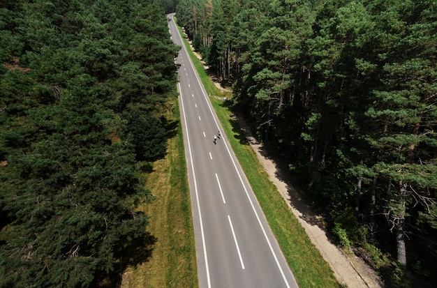 Foto gratuita mujeres ciclistas profesionales de tiro largo en la carretera