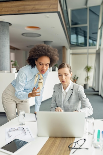 Mujeres colegas de negocios trabajando en una computadora en la oficina