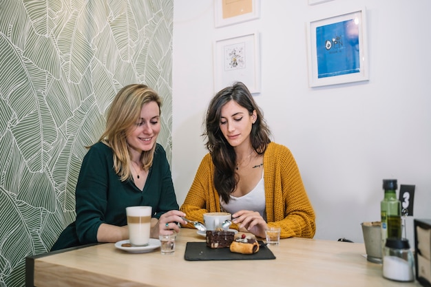 Mujeres comiendo y bebiendo en la cafetería