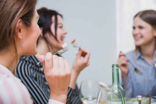 Mujeres comiendo bocadillos con tenedores