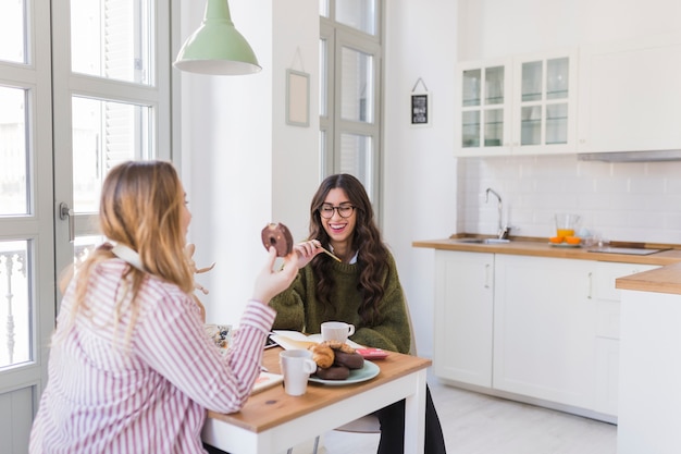 Mujeres comiendo y dibujando en la cocina