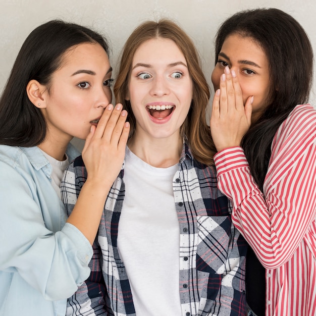 Foto gratuita mujeres compartiendo un secreto chocante para divertirse