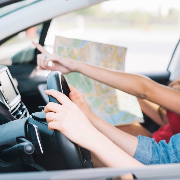 Mujeres conduciendo coche con mapa