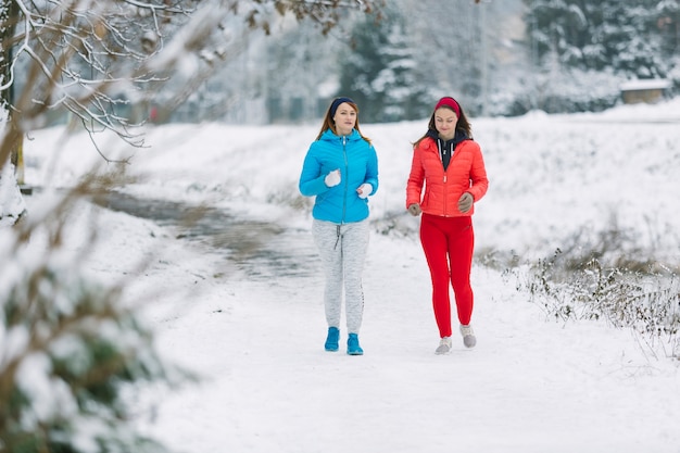 Mujeres corriendo en el parque de invierno