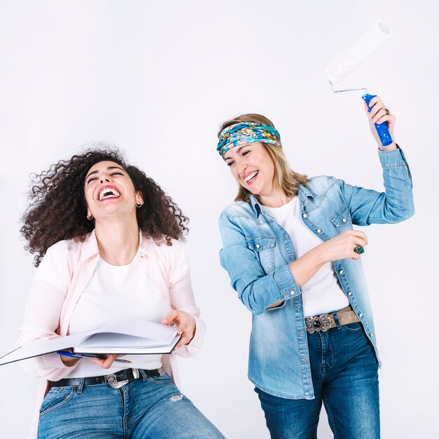 Mujeres con cuaderno y rodillo de pintura