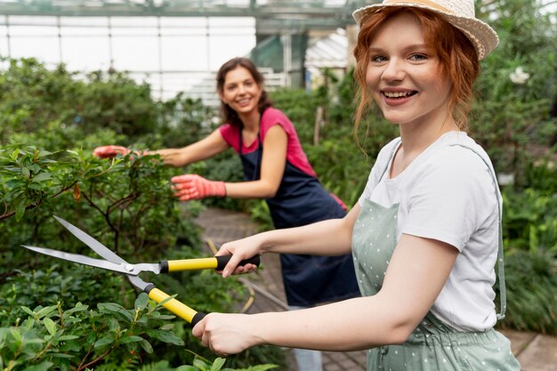 Mujeres cuidando sus plantas en invernadero.