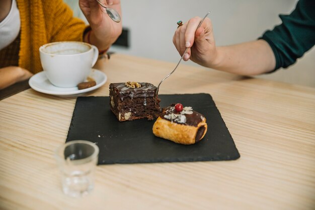 Mujeres de cultivos comiendo postre en café