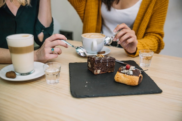 Mujeres de cultivos disfrutando de postre y bebida