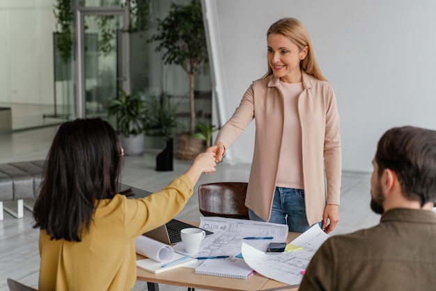 Foto gratuita mujeres dándose la mano en el trabajo