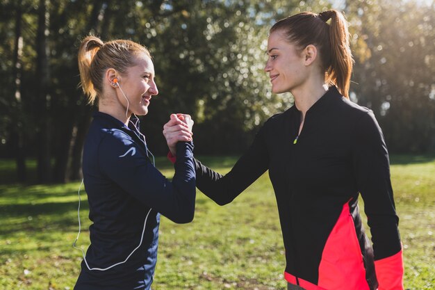 Mujeres deportistas dándose buena suerte