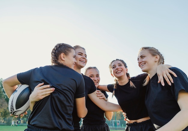 Mujeres deportivas sonrientes que se abrazan