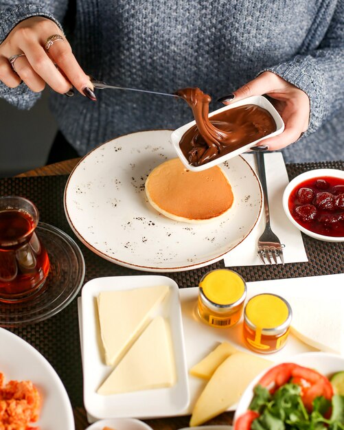 Las mujeres desayunan con crema de chocolate y panqueques