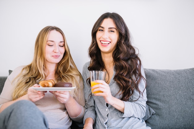 Mujeres desayunando en el sofá