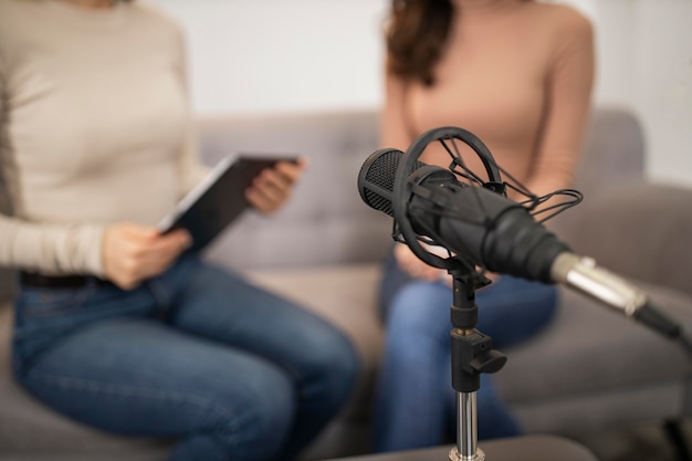 Mujeres desenfocadas haciendo una entrevista de radio con micrófono