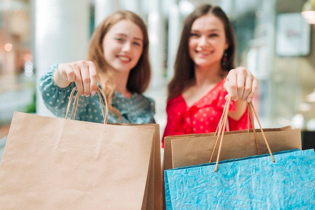 Foto gratuita mujeres desenfocadas mostrando bolsas