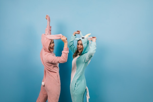 Mujeres despreocupadas divertidas posando en kigurumi