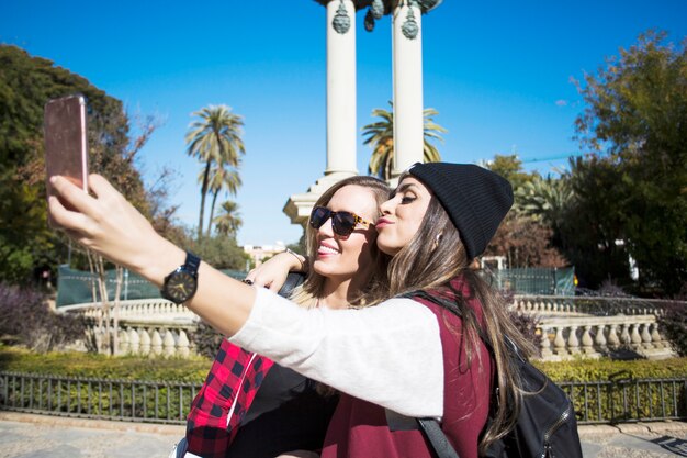 Mujeres divertidas tomando selfie en la calle