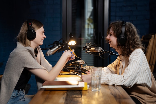 Mujeres ejecutando un podcast mientras usan auriculares