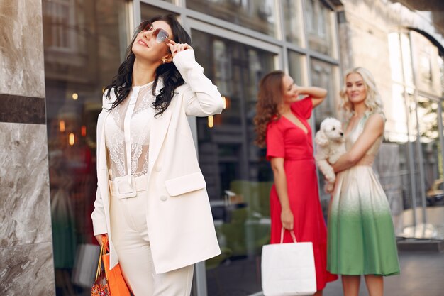 mujeres elegantes con bolsas de compras en una ciudad