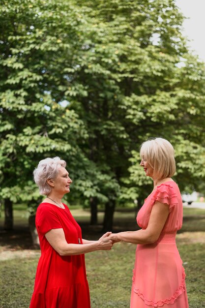 Mujeres elegantes maduras cogidos de la mano