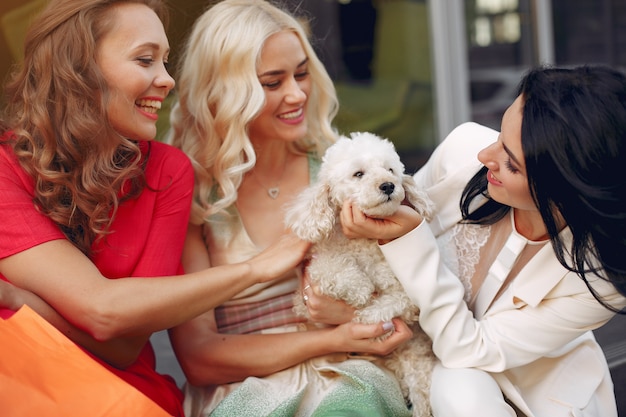 mujeres elegantes con perrito en una ciudad