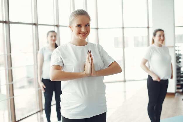 Mujeres embarazadas haciendo yoga en un gimnasio