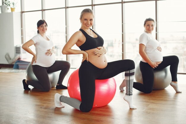 Mujeres embarazadas haciendo yoga en un gimnasio