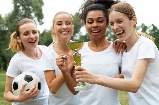 Foto gratuita mujeres emocionadas con copa de ganadores