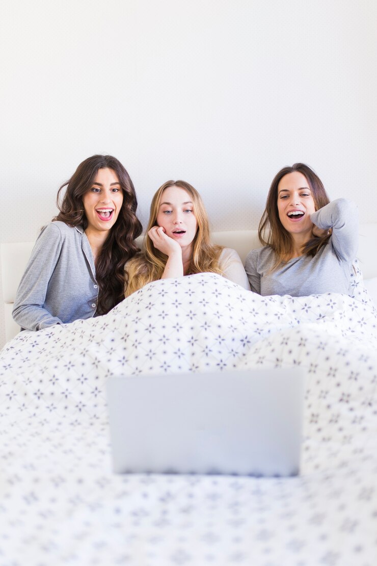 Foto gratuito mujeres emocionadas viendo películas en la cama