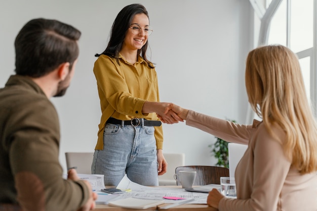 Mujeres empresarias dándose la mano en el trabajo