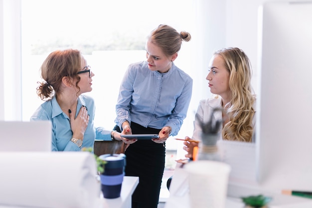 Mujeres empresarias discutiendo entre sí sobre el plan de negocios en la oficina