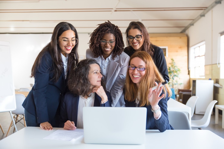 Foto gratuito mujeres empresarias felices trabajando con laptop