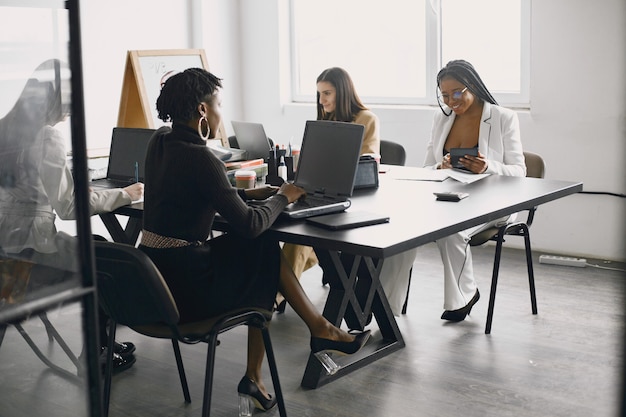 Mujeres empresarias multiculturales en reunión de grupo.