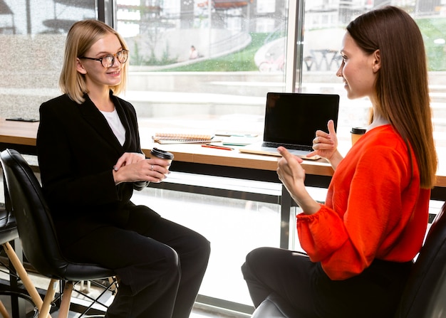 Mujeres empresarias que utilizan el lenguaje de señas en el trabajo para comunicarse