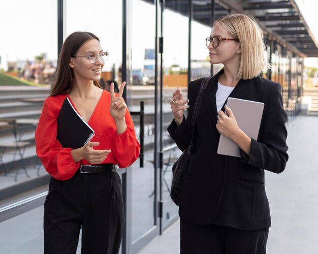 Mujeres empresarias utilizando lenguaje de señas fuera