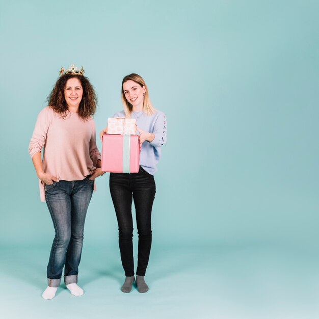 Mujeres encantadoras con corona y regalos