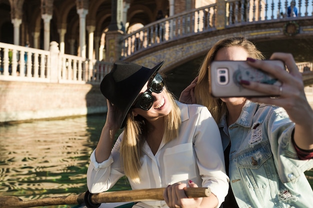 Foto gratuita mujeres encantadoras posando para selfie en barco