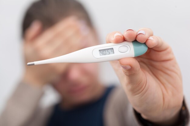 Mujeres enfermas con termómetro