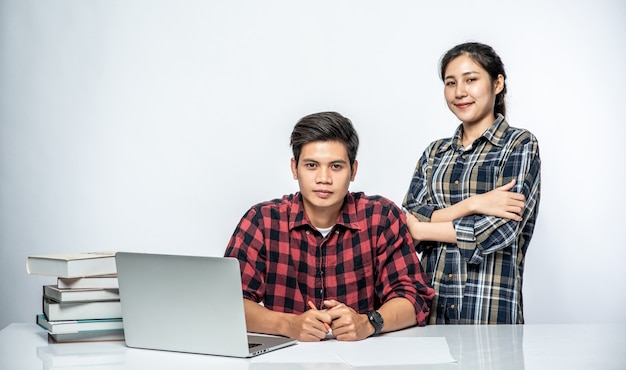 Las mujeres enseñan a los hombres cómo trabajar con computadoras portátiles.