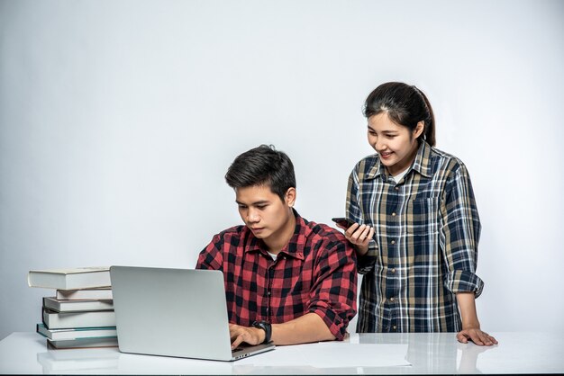 Las mujeres enseñan a los hombres cómo trabajar con computadoras portátiles.