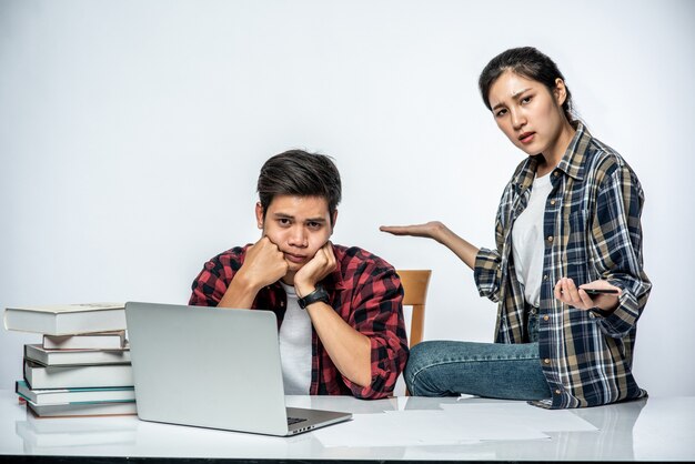 Las mujeres enseñan a los hombres cómo trabajar con computadoras portátiles.