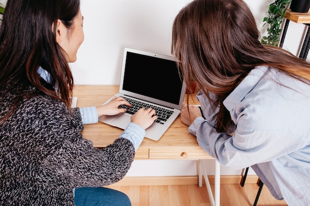 Foto gratuita mujeres escribiendo en la computadora portátil