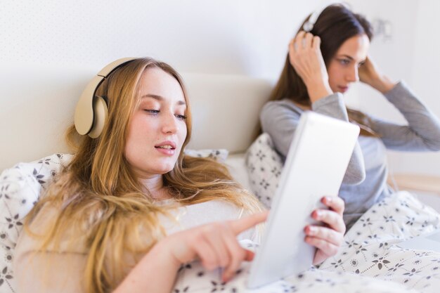Mujeres escuchando música en la cama