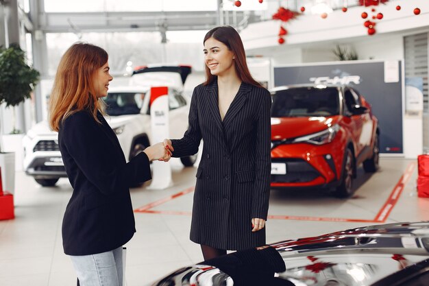 Mujeres con estilo y elegantes en un salón de autos