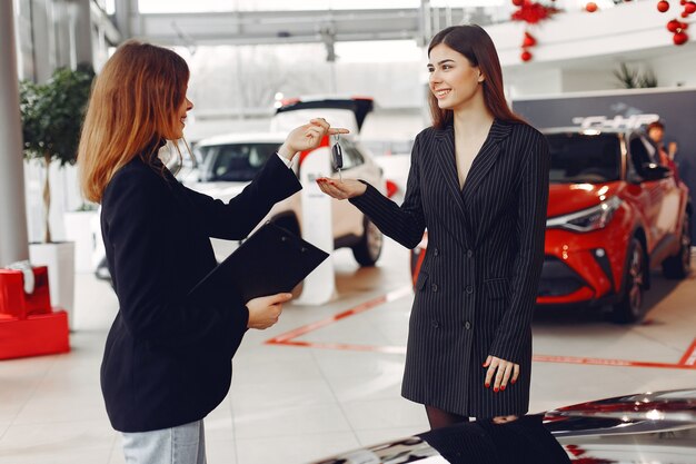 Mujeres con estilo y elegantes en un salón de autos