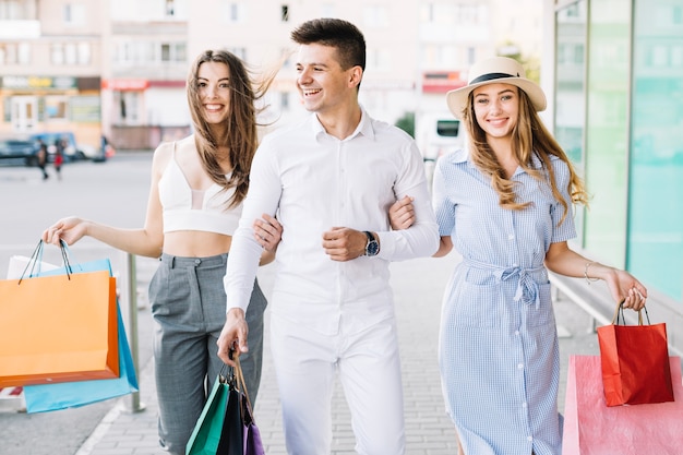 Mujeres con estilo con hombre de compras juntos